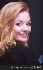 Beautiful smiling girl with blond wavy hair by hairdresser. Young woman in hairdressing beauty salon. Hairstyle.