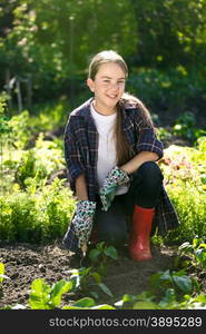 Beautiful smiling girl working at garden at hot sunny day