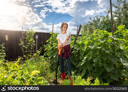 Beautiful smiling teenage girl helping digging soil in garden. Smiling teenage girl helping digging soil in garden