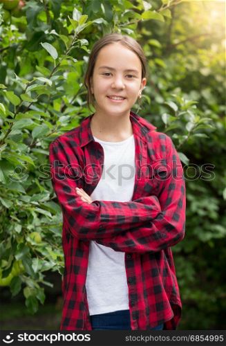 Beautiful smiling teenage girl posing at garden