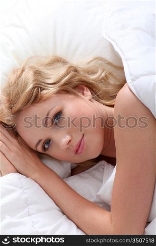 Beautiful smiling woman laying in bed