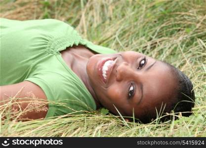 Beautiful smiling woman laying in the long grass
