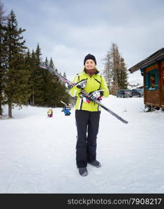 Beautiful smiling woman posing with skis on slope