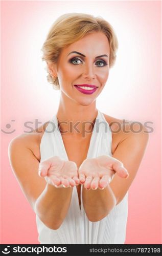 Beautiful smiling woman showing something on the palms of her hands. on color background