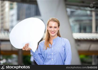 Beautiful smiling women holding white board while standing outdoor