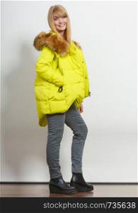 Beautiful smiling young fashionable girl wearing jacket with hood. Fashion in winter time.