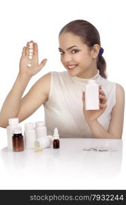 Beautiful smiling young woman showing an exclamation mark made from pills on her palm and holding a pill bottle