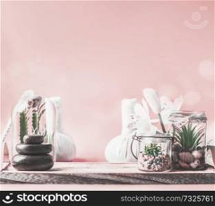 Beautiful spa setting background with steak of massage stones, succulent plants and wellness equipment on table at pastel pink wall. Healthy lifestyle , beauty, relaxing and spoiling concept