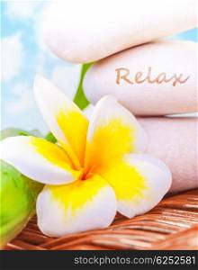 Beautiful spa still life on the beach, spa stones, yellow frangipani flower, tropical resort, summer holiday, dayspa, exotic treatment concept