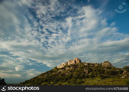 Beautiful Spanish old castle over a hill with a amazing sky of background