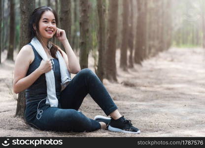 Beautiful sport young woman girl lifestyle exercise healthy drinking water from bottle after running workout in forest nature park with copy space