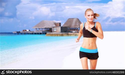 Beautiful sportive female running on the beach, workout on luxury Maldives resort, doing fitness exercises outdoors, healthy lifestyle, active summer vacation concept