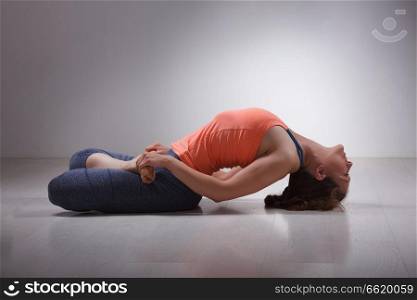 Beautiful sporty fit yogini woman practices yoga asana Matsyasana - fish pose in studio. Beautiful sporty fit yogi girl practices yoga asana Matsyasana