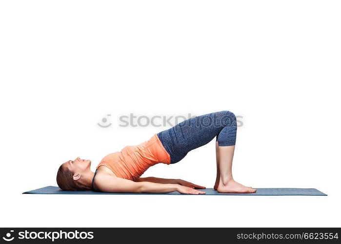 Beautiful sporty fit yogini woman practices yoga asana setu bandhasana - bridge pose beginner variation in studio isolated on white. Beautiful sporty fit yogi girl practices yoga asana setu bandhasana