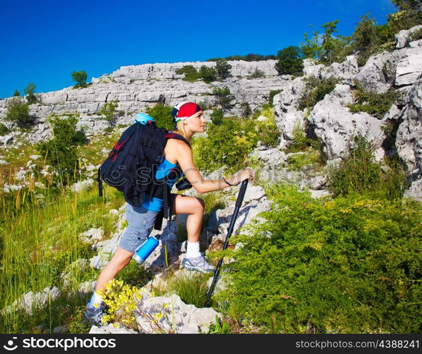 Beautiful sporty teenager girl climbing on mountain, active lifestyle, extreme sport, summer vacation, hiking and trekking concept