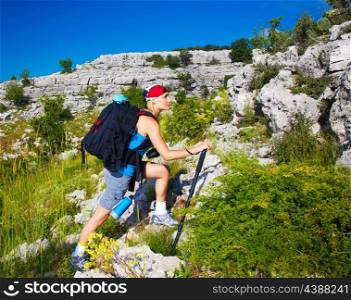 Beautiful sporty teenager girl climbing on mountain, active lifestyle, extreme sport, summer vacation, hiking and trekking concept