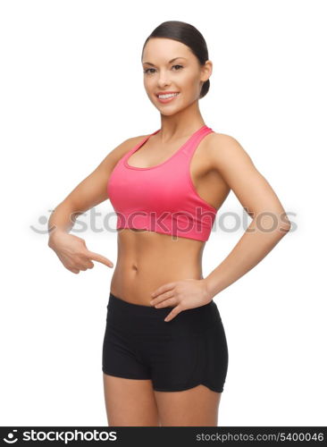 beautiful sporty woman pointing finger on her belly