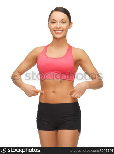 beautiful sporty woman pointing finger on her belly