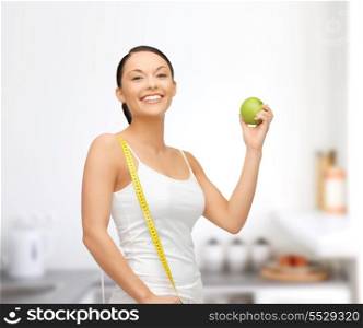 beautiful sporty woman with apple and measuring tape