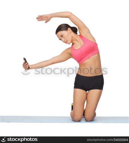 beautiful sporty woman with smartphone doing exercise