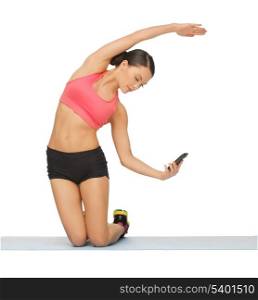 beautiful sporty woman with smartphone doing exercise