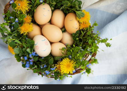 Beautiful spring bouquet in a wooden basket with Easter painted eggs, eggs with cute faces. Easter postcard. Beautiful spring bouquet in a wooden basket with Easter painted eggs, eggs with cute faces. Easter postcard.