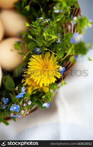 Beautiful spring bouquet in a wooden basket with Easter painted eggs, eggs with cute faces. Easter postcard. Close-up. Beautiful spring bouquet in a wooden basket with Easter painted eggs, eggs with cute faces. Easter postcard. Close-up.