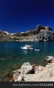 Beautiful St Pauls Bay shadowed by the temple and castle ruins at Lindos