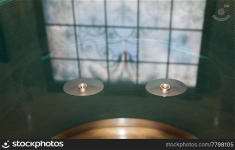 beautiful stained glass and wedding rings on the glass table