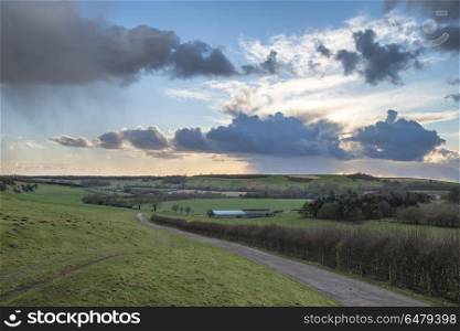 Beautiful stormy moody cloudy sky over English countryside lands. Beautiful stormy dramatic cloud formations over English countryside landscape