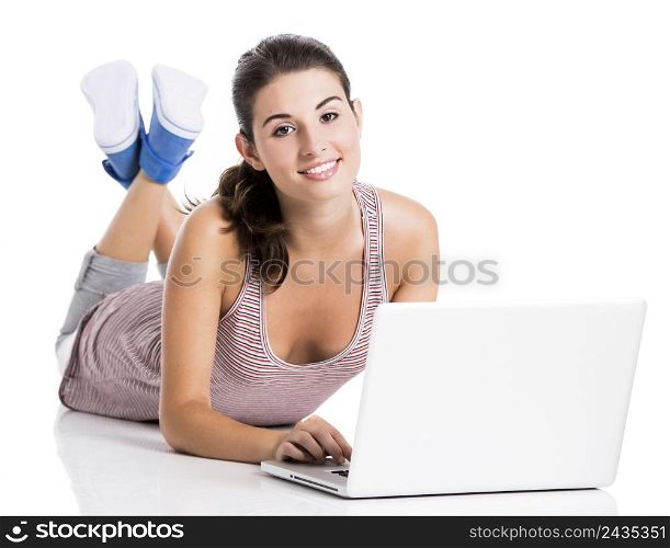 Beautiful student lying in the floor working in a laptop, isolated over a white background