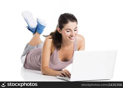 Beautiful student lying in the floor working in a laptop, isolated over a white background