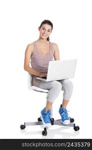 Beautiful student sitting in a chair with a laptop, isolated over a white background