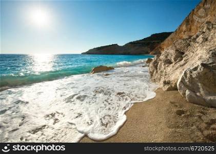 Beautiful summer coast Porto Katsiki beach on Ionian Sea (Lefkada, Greece) with sun in sky and wave