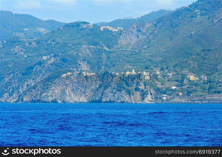Beautiful summer Corniglia view from excursion ship. One of five famous villages of Cinque Terre National Park in Liguria, Italy, suspended between Ligurian sea and land on sheer cliffs.