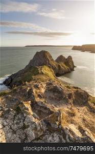 Beautiful Summer evening sunset beach landscape image at Three Cliffs Bay in South Wales