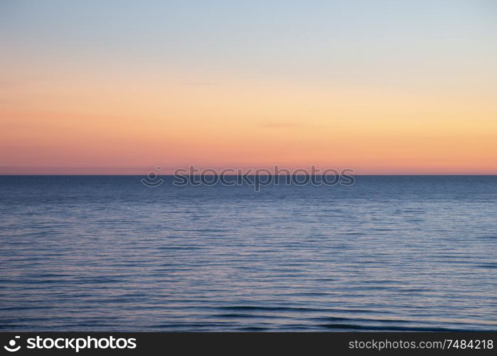 Beautiful Summer landscape sunset image of colorful sky over calm long exposure sea