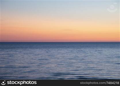 Beautiful Summer landscape sunset image of colorful sky over calm long exposure sea