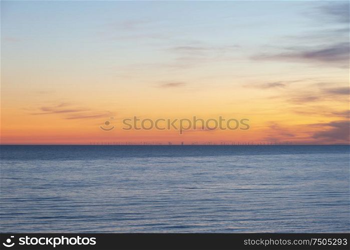Beautiful Summer landscape sunset image of colorful sky over calm long exposure sea