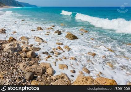 Beautiful summer Lefkada coast stony beach, Greece, Ionian Sea. People unrecognizable.