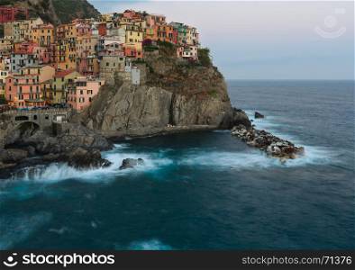 Beautiful summer Manarola - one of five famous villages of Cinque Terre National Park in Liguria, Italy, suspended between Ligurian sea and land on sheer cliffs. People unrecognizable.