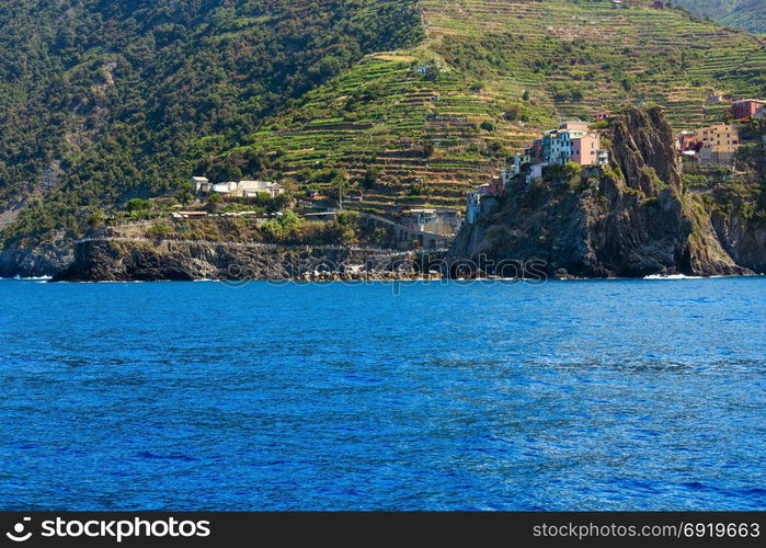 Beautiful summer Manarola view from excursion ship. One of five famous villages of Cinque Terre National Park in Liguria, Italy, suspended between Ligurian sea and land on sheer cliffs.