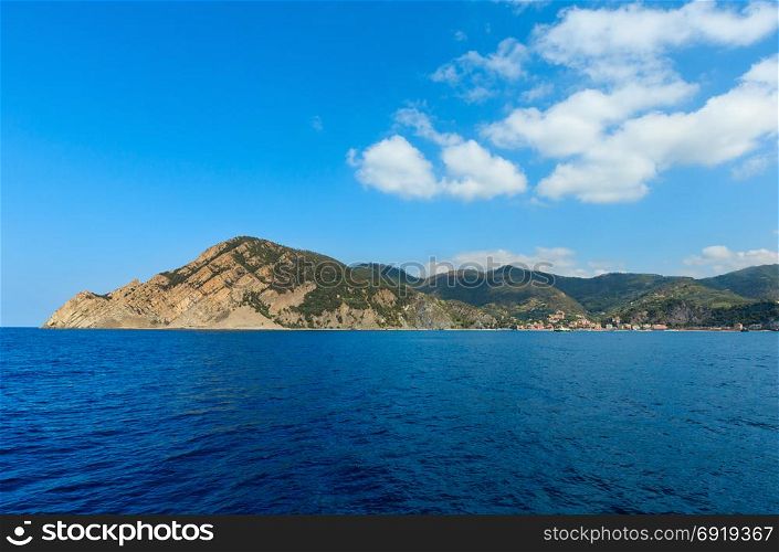 Beautiful summer Monterosso view from excursion ship. One of five famous villages of Cinque Terre National Park in Liguria, Italy, suspended between Ligurian sea and land on sheer cliffs.