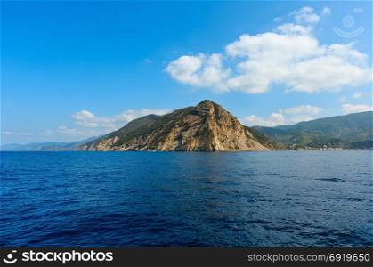 Beautiful summer Monterosso view from excursion ship. One of five famous villages of Cinque Terre National Park in Liguria, Italy, suspended between Ligurian sea and land on sheer cliffs.