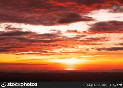 Beautiful summer red vibrant burning sunset or sunrise sky with clouds and mountain range