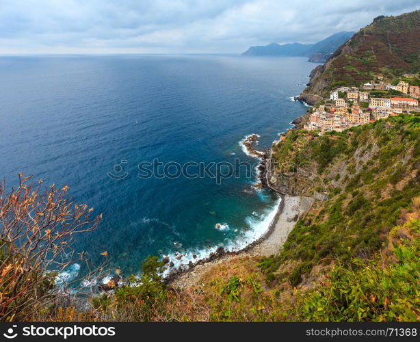 Beautiful summer Riomaggiore - one of five famous villages of Cinque Terre National Park in Liguria, Italy, suspended between Ligurian sea and land on sheer cliffs. People are unrecognizable.