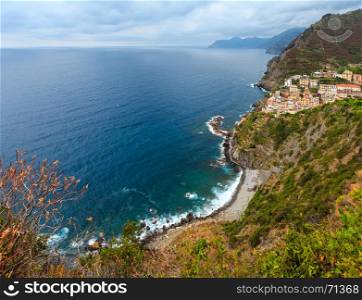 Beautiful summer Riomaggiore - one of five famous villages of Cinque Terre National Park in Liguria, Italy, suspended between Ligurian sea and land on sheer cliffs. People are unrecognizable.