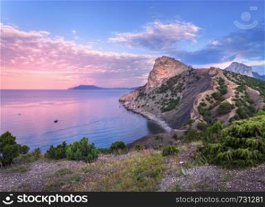 Beautiful summer sunset at the sea with mountains, trees and blue sky in Crimea