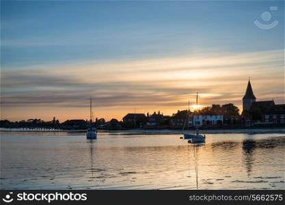 Beautiful Summer sunset landscape over low tide harbor with boats