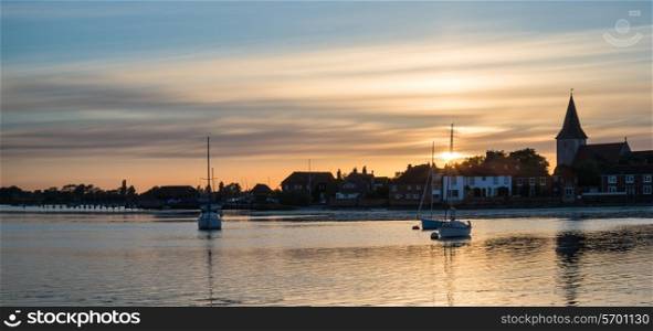 Beautiful Summer sunset landscape over low tide harbor with boats